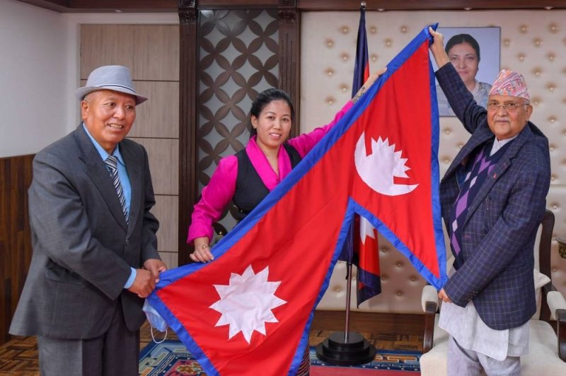 PM Oli hands over national flag to mountaineer Maya Sherpa prior to her Annapurna-Dhaulagiri expedition